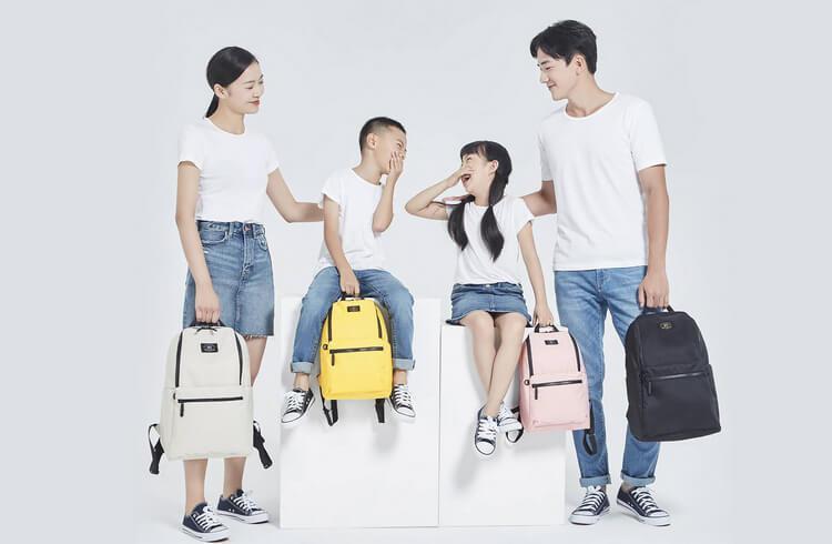Молодая семья с детьми держат в руках рюкзаки Ninetygo Light Travel