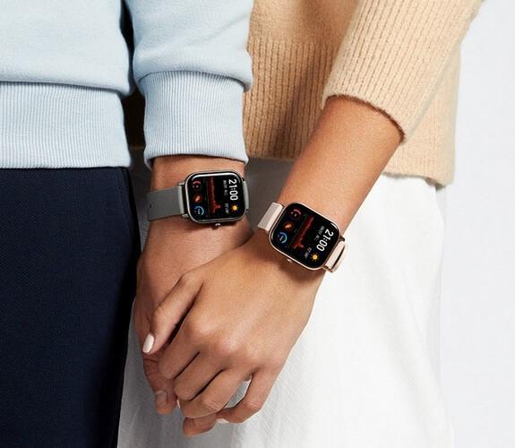 Часы Xiaomi Amazfit GTS на запястьях рук парня и девушки